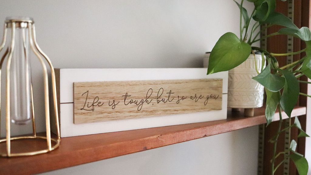 A decorative sign that says "Life is tough, but so are you."